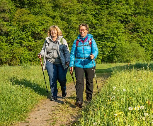 2 Wanderinnen sind auf einem Feldweg unterwegs